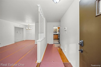 Corridor with a chandelier and wood finished floors