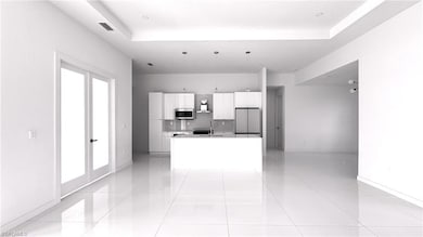 Kitchen with backsplash, fridge, light tile patterned floors, and a raised ceiling