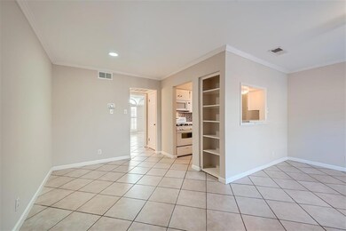 Spare room featuring crown molding, light tile pa