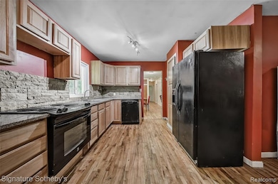 Kitchen with maple cabinets, granite counters, and stone backsplash