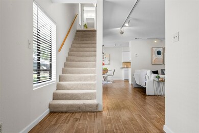 Stairs with track lighting, wood finished floors,