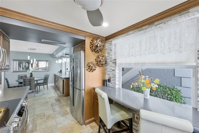 Dining area featuring stone tile floors, crown mol
