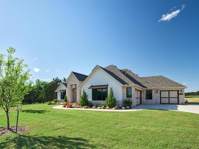 View of front facade with an attached garage, concrete driveway, a front lawn, stucco siding, and a shingled roof