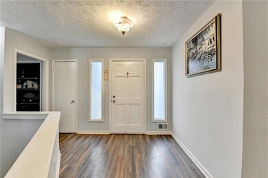 Entrance foyer with visible vents, dark wood-style