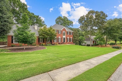 View of front of property with brick siding, a front lawn, and a chimney