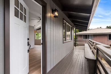Front Entrance of Home Features a Built In Bench Along the Lanai Railing