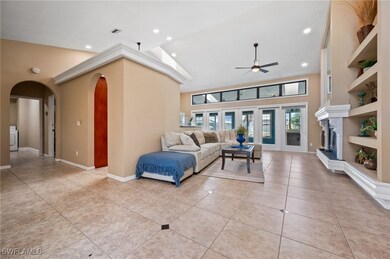 Living room with arched walkways, ceiling fan, lig