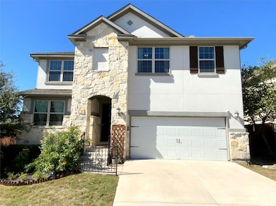 View of front of property with stone siding, an attached garage, concrete driveway, and stucco siding