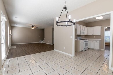 Kitchen with white appliances, white cabinetry, a 