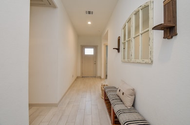 Hallway leading to front door and secondary bedrooms