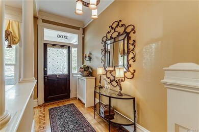 Stunning Foyer with inlaid wood, chandelier, glass door with sidelights, crown molding