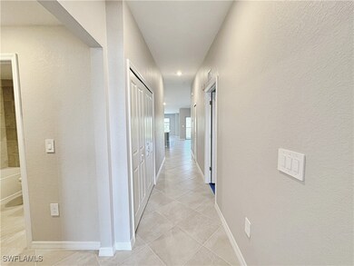 Hall with light tile patterned floors, baseboards,