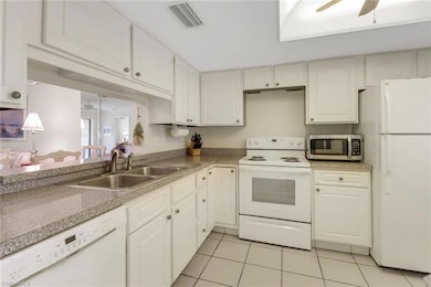 Kitchen featuring white appliances, light tile pat