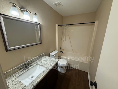 Full bath with vanity, wood finished floors, and shower / bathtub combination