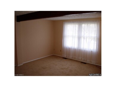 The living room has an exposed beam, fresh paint a