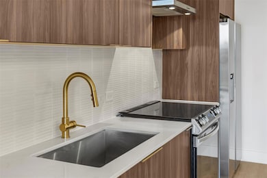 Kitchen featuring a sink, modern cabinets, stainl