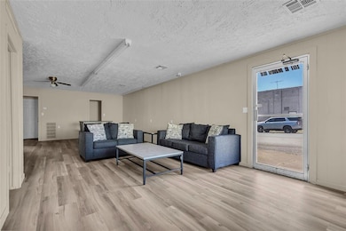 Living room with a textured ceiling, visible vents