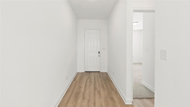 Hallway featuring baseboards and light wood-type flooring