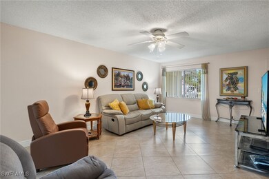 Tiled living room with ceiling fan and a textured