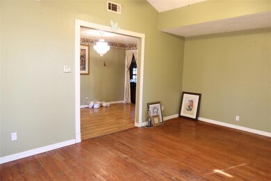 Empty room with wood-type flooring and vaulted cei