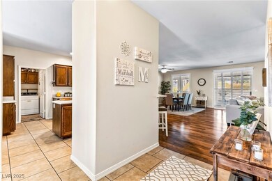 Hallway with washer / dryer, baseboards, and light