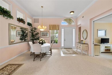 Carpeted foyer featuring crown molding, tile patterned floors, and a chandelier