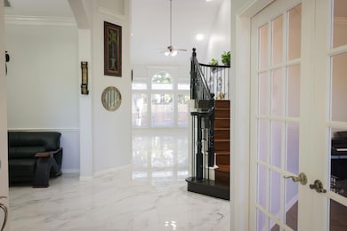 Corridor with light marble finish flooring, crown molding, recessed lighting, stairway, and french doors