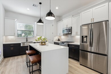 A beautiful waterfall island, two tone cabinetry,