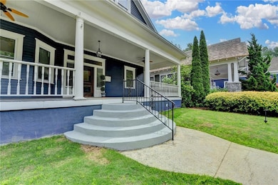 Property entrance with a lawn, a ceiling fan, and a porch
