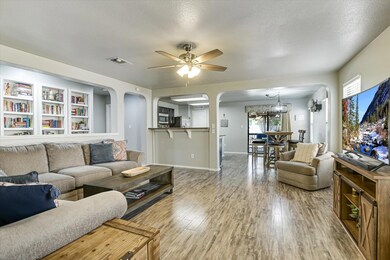 Living area with arched walkways, wood finished f