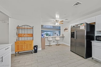 Kitchen featuring black microwave, light counterto