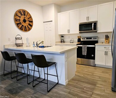 Kitchen featuring a sink, white cabinetry, a break