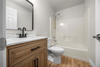 Bathroom featuring bathing tub / shower combination, light wood-type flooring, and vanity