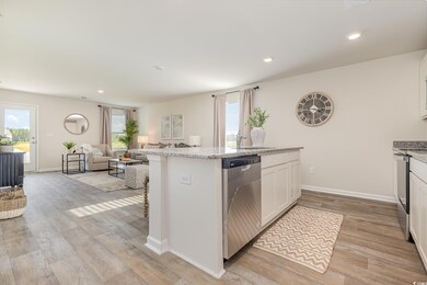 Kitchen with dishwasher, stove, open floor plan, light wood finished floors, and white cabinets