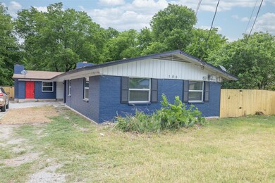 View of front facade featuring brick siding and a chimney