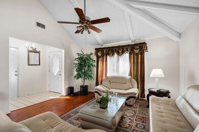 Living room featuring visible vents, beamed ceilin