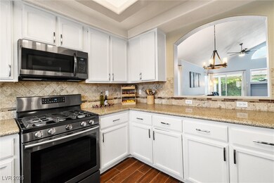 Kitchen with dark wood-type flooring, arched walkw
