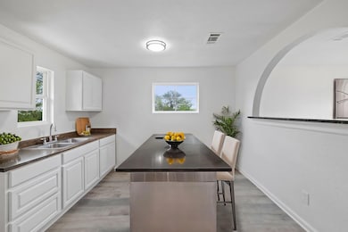 Kitchen with a sink, dark countertops, a breakfas