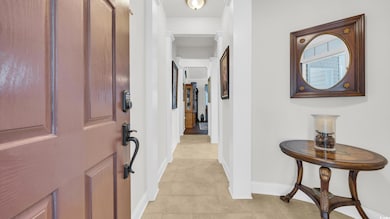 Foyer with baseboards and light tile patterned floors