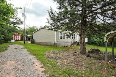 View of side of home with entry steps, driveway, and a lawn