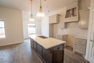 Kitchen with decorative light fixtures, backsplash