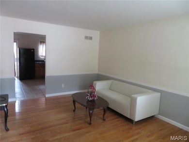 Sitting room featuring light wood-style floors and baseboards
