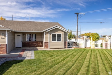View of front of home featuring brick siding, a shingled roof, and covered porch
