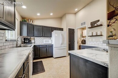 Kitchen featuring tasteful backsplash, white appli