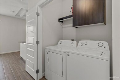 Washroom with washing machine and clothes dryer and light hardwood / wood-style flooring