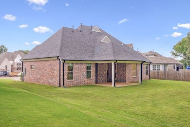 Rear view of house featuring roof with shingles, brick siding, and a patio