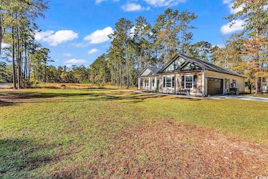 View of front of property featuring a front lawn, driveway, an attached garage, and a porch