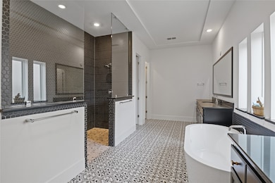 Luxurious primary bathroom featuring a stunning wa