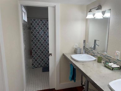 Full bathroom featuring a textured wall, a shower
