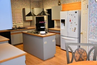 Kitchen featuring wallpapered walls, light counter